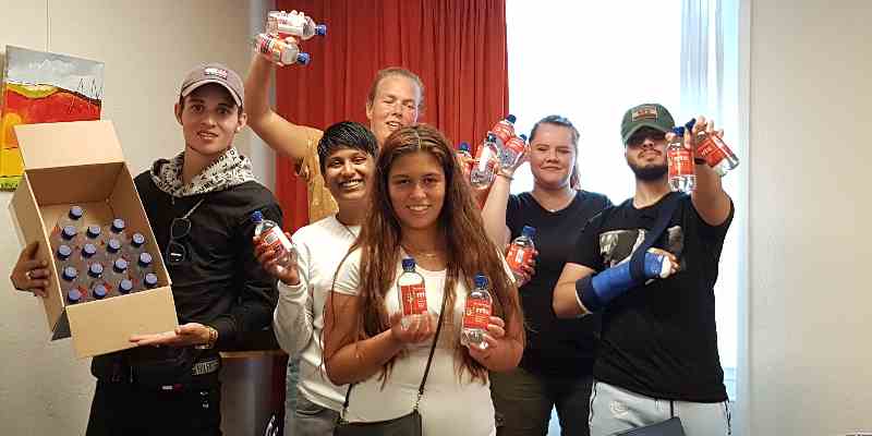 Achterban jongeren delen flesjes water uit aan hun leeftijdsgenoten
