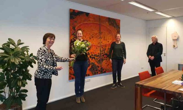 Wethouder Bert van Alphen ontvangt bloemen voor actieplan jongeren